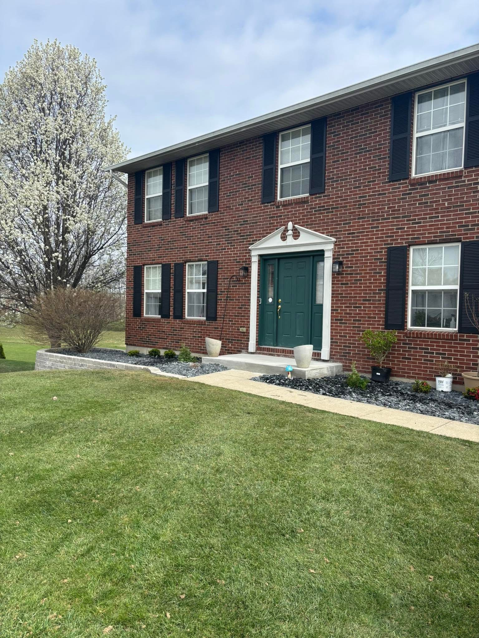 Brick home with freshly installed decorative rock and mulch landscape beds