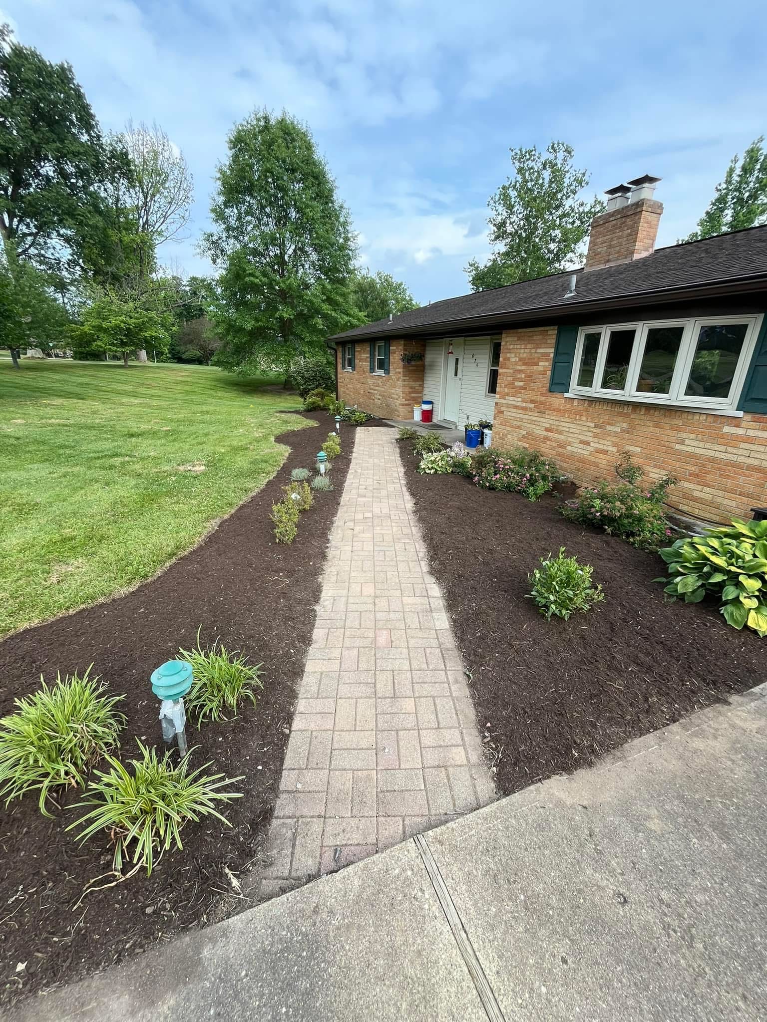 Custom paver walkway with rich mulch beds and lush plantings